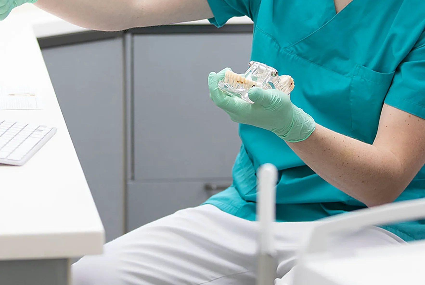Ein Implantatmodell in der Hand des Behandlers bei der Beratung